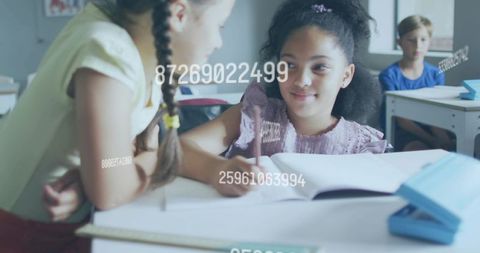 Girls collaborating and writing with floating numeric overlay in modern classroom scene