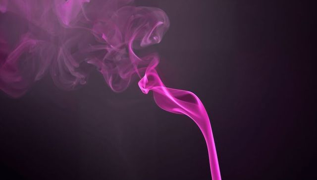 Swirling magenta smoke creating abstract patterns