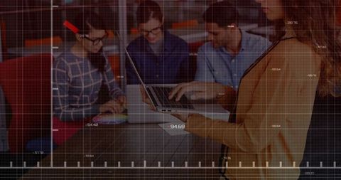 Collaborating team leaning over laptop analyzing dashboards with digital grid overlay in office