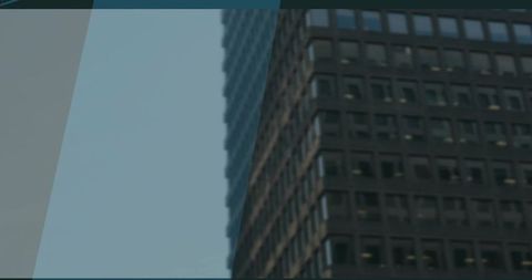 Office Skyscraper Facade with Dark Windows Under Blue Sky