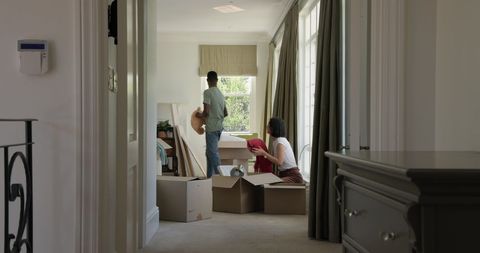 Couple unpacking boxes in new home celebrating relocation