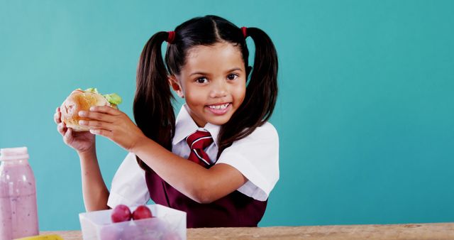 Smiling Schoolgirl Eating Healthy Lunch and Holding Sandwich - Download Free Stock Images Pikwizard.com