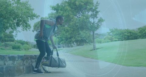 Athletic Man Lifting Duffel Bag in Urban Park