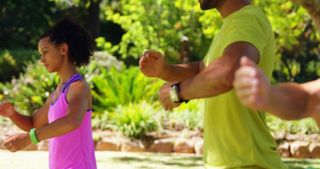 This photo depicts a diverse group of people practicing Tai Chi in an outdoor park. Perfect for illustrating themes of fitness, health, meditation, and outdoor activities. Can be used in articles, blog posts, or advertisements promoting healthy living, exercise routines, or community fitness programs.