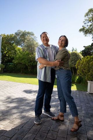 Joyful Couple Embracing in Sunlit Backyard