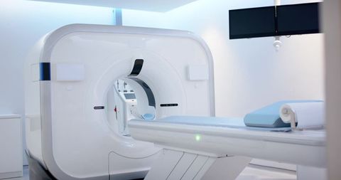 Showcasing ct gantry in modern radiology suite with patient table and monitors, clean minimal look