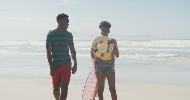 Couple Enjoying a Walk on Sunny Beach - Download Free Stock Images Pikwizard.com