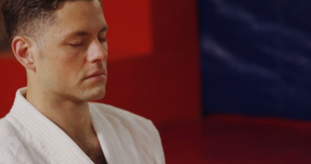 Man Meditating in Martial Arts Gi Focused on Inner Peace - Download Free Stock Images Pikwizard.com