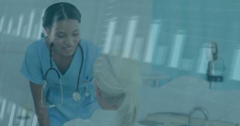 Nurse leaning and comforting patient at bedside with digital health data overlay