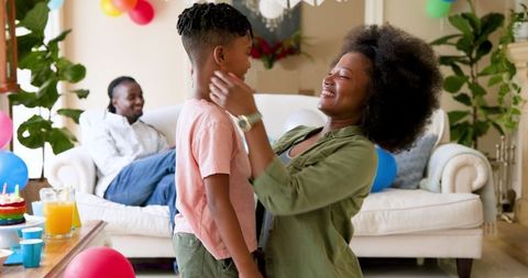 Mother Embracing Son During Birthday Celebration at Home