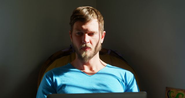 Man Focusing on Laptop Screen at Home with Sunlit Face - Download Free Stock Images Pikwizard.com