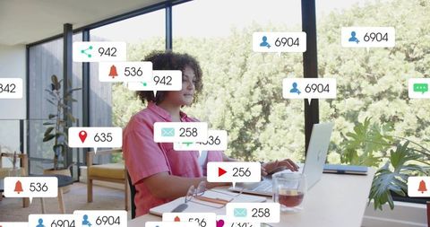 Remote professional typing on laptop surrounded by social notifications in home office