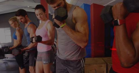 Group strength training: muscular man curling dumbbell with plyo boxes
