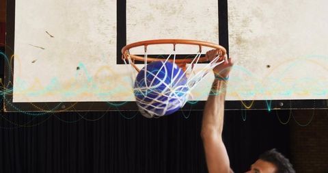 Dunking athlete sending blue basketball through orange rim with neon waveform overlay