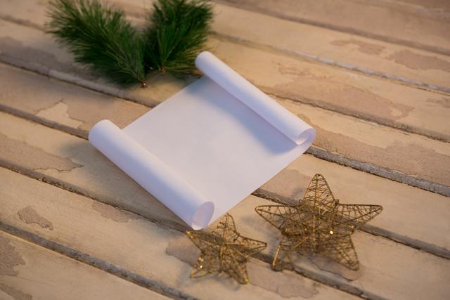 Christmas fir, star and paper on wooden plank during christmas time