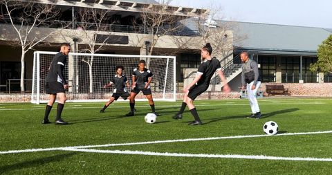 Teen Soccer Players Practicing Pass Drills on Sunny School Field