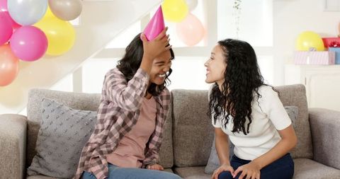 Two Women Laughing During Fun Birthday Celebration at Home