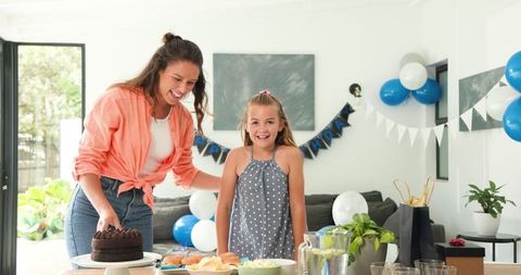 Mother and Daughter Preparing Birthday Celebration in Living Room
