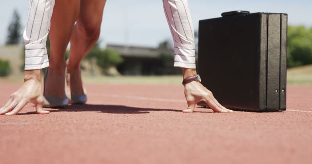 Image showcases businessperson in starting position on running track with briefcase, symbolizing readiness for career challenges and goals. Perfect for use in articles, blogs, and advertisements promoting business strategy, career growth, productivity, and competitive spirit.