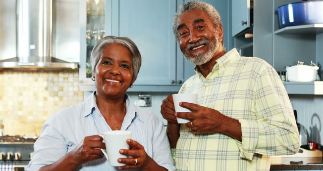 Senior couple having coffee in kitchen at home