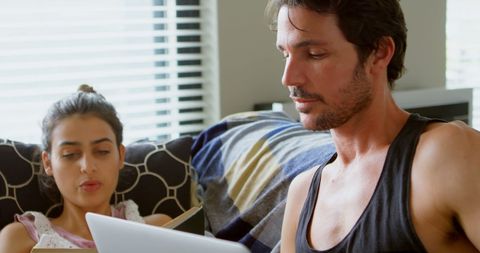 Man and Woman Collaborating at Home Using Laptop