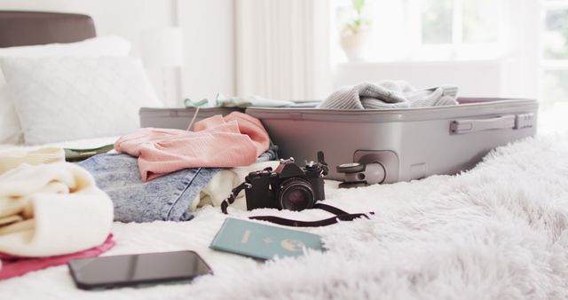 Image of passport, smartphone, camera, clothes and suitcase on bed. Travel, vacation, leisure time, domestic life and lifestyle concept.