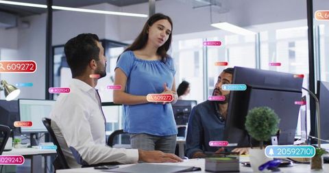 Team discussing project around desk with floating data labels in modern office collaboration