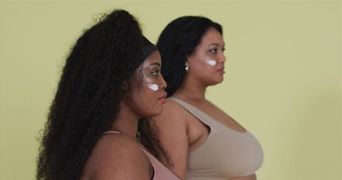 Two female models applying under-eye cream for skincare