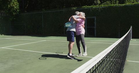 Active Senior Couple Hugging on Tennis Court