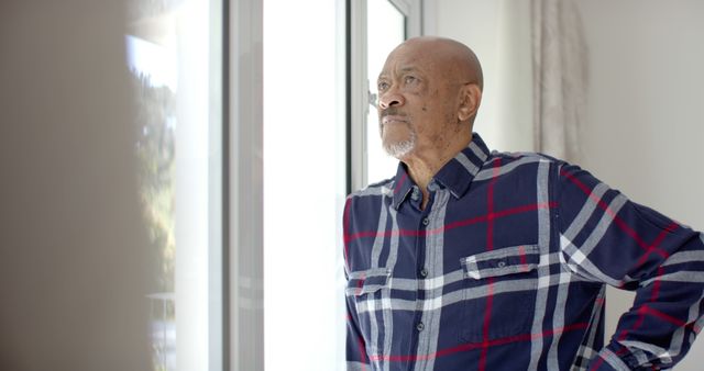 Thoughtful Senior Man Looking Out Window in Living Room - Download Free Stock Images Pikwizard.com