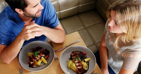 Couple Enjoying Meal Together in Cozy Restaurant Setting