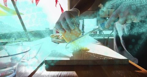 Chef slicing cheese with knife on rustic wooden board in bright kitchen