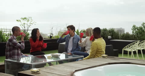 Group of Friends Enjoying Rooftop Gathering with Drinks
