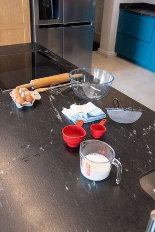 Kitchen island showcasing baking tools and ingredients on dark marble countertop