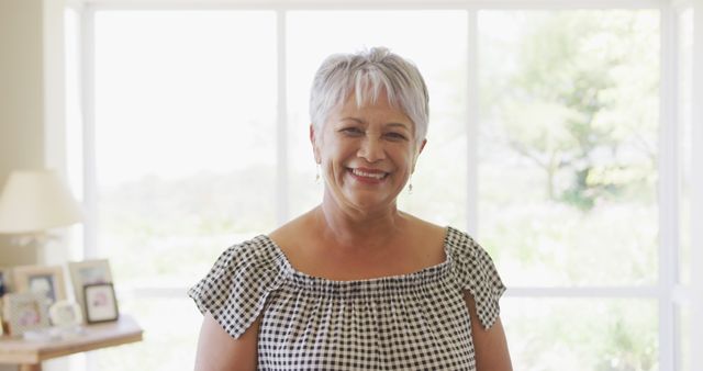 Smiling Senior Woman Standing by Bright Window at Home - Download Free Stock Images Pikwizard.com