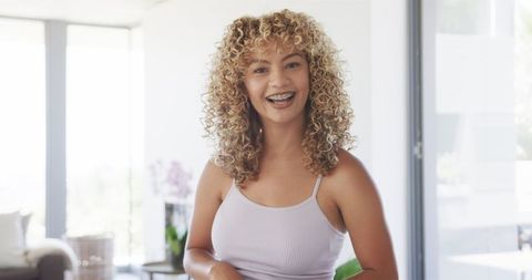 Smiling Young Woman with Curls Enjoying Video Call
