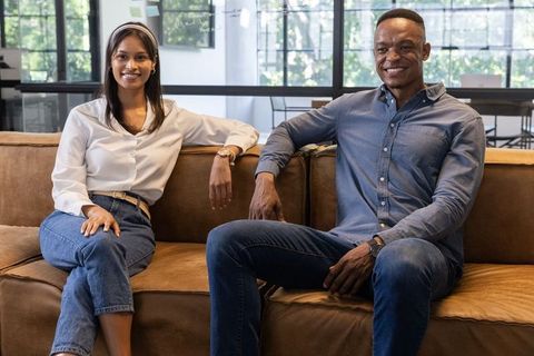 Diverse professionals sitting on couch conducting informal meeting