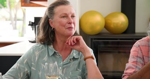 Senior Woman Relaxing with Friends and Wine at Home