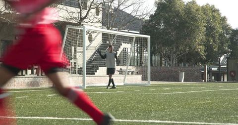 Goalkeeper Preparing in Sunlit Soccer Field