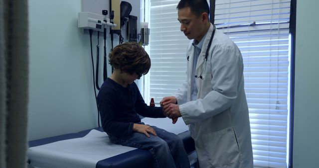 Pediatrician Examining Young Boy's Wrist In Medical Clinic - Download Free Stock Images Pikwizard.com