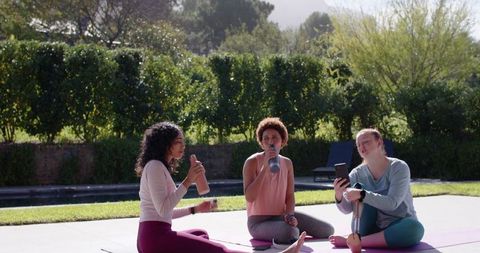 Diverse Friends Relaxing After Outdoor Yoga Session on Sunny Patio