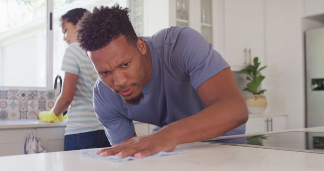 Happy african american couple washing dishes in kitchen. Spending quality time at home together concept.