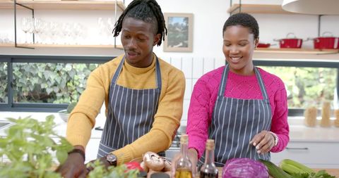 Smiling Couple in Kitchen Preparing a Meal Together