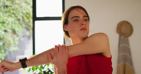 Non-Binary Individual Practicing Yoga and Stretching at Home