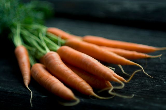 Fresh Organic Carrots with Green Tops on Dark Rustic Background - Download Free Stock Photos Pikwizard.com