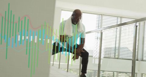 Resting mature man leaning on railing in modern atrium with fitness data overlay