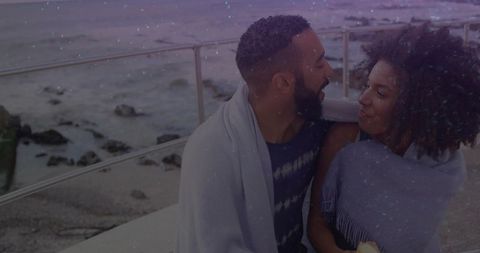 Romantic Couple Wrapped in Blankets on Scenic Seaside