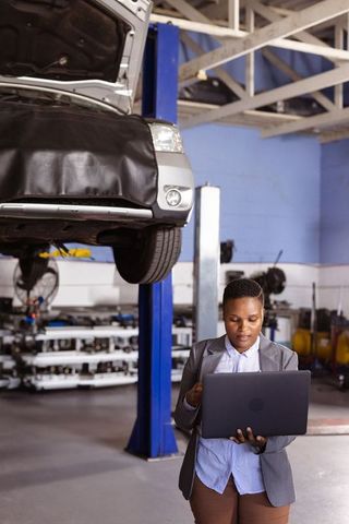 Woman in Auto Workshop Analyzing Car Diagnostics on Laptop - Download Free Stock Images Pikwizard.com