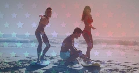 three friends engaging in surfing practice on a sandy beach, casting uniquely patriotic holiday vibes with layered, transparent star graphics. as the sun sets over the ocean, the serene warm tones imply leisure and american independence spirit. perfect for marketing campaigns focused on national holidays, travel promotions, and lifestyle brands celebrating outdoor adventures and seasonal sports activities.