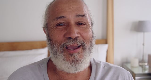 Joyful Elderly Man with White Beard Smiling in Bedroom - Download Free Stock Images Pikwizard.com